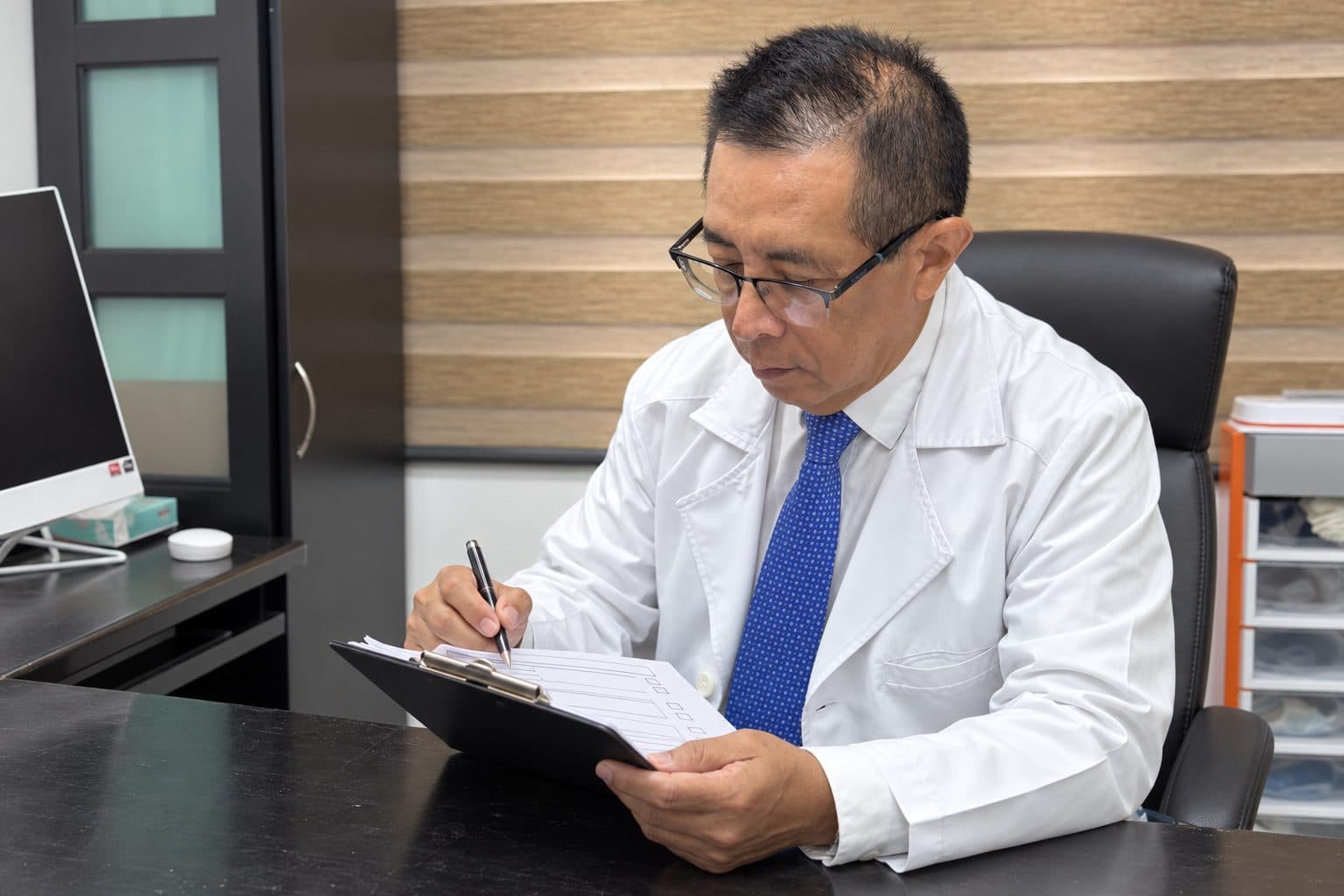 Dr. Carlos Alejos revisando el expediente de una paciente